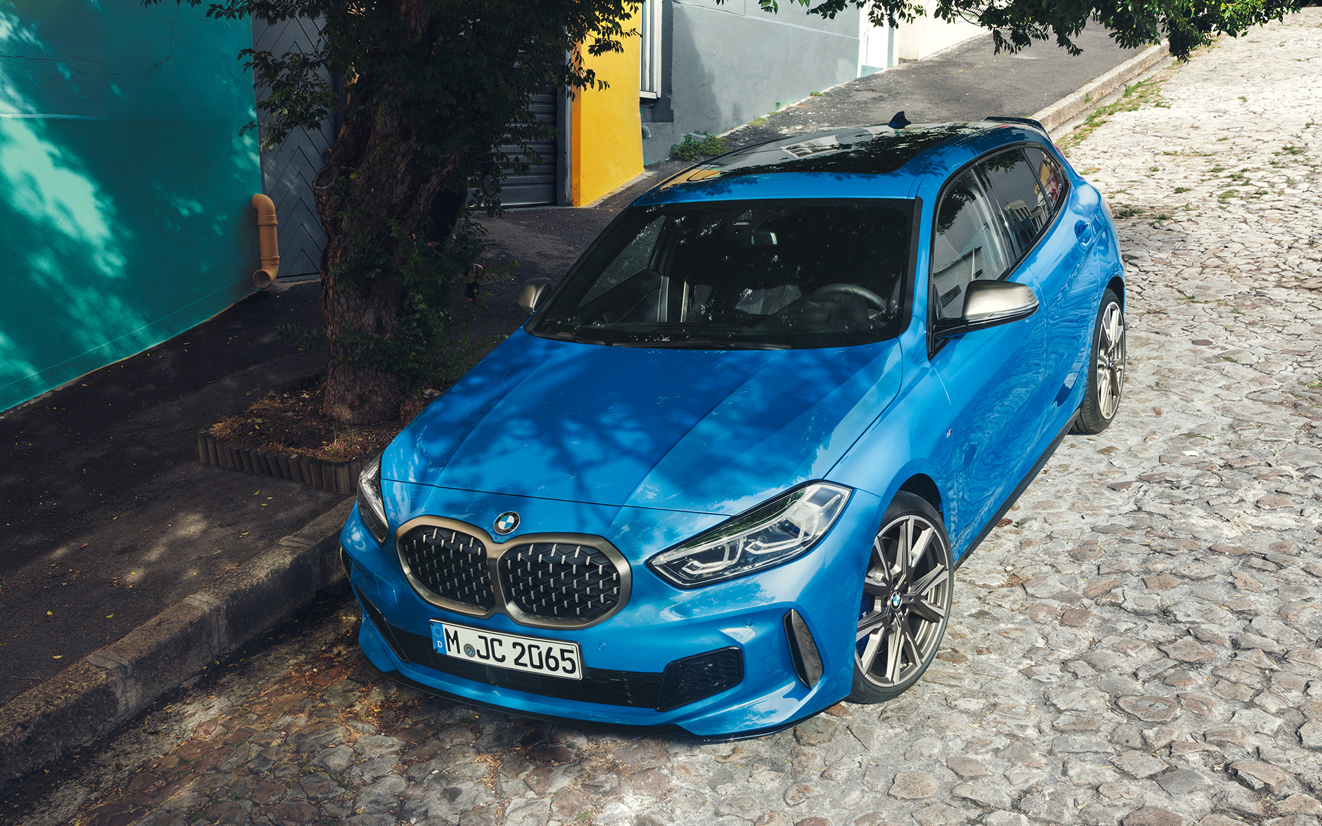 BMW 1 Series M135i F40 in Misano Blue metallic, three-quarter front view, parking at the roadside from a bird’s eye view